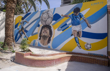 Buenos Aires, Argentina.- En las fotos tomadas el 11 de octubre del 2023, muestra "Maradona como el D10S que cuida su templo", el nuevo homenaje a Diego en su vieja casa de Devoto. La obra, fue presentada por sus autores intelectuales y ejecutores, la directora de arte Mariana Bianchini, y al muralista Gastón Liberto, haciendo un nuevo homenaje al máximo ídolo futbolero de la Argentina.