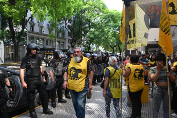 Buenos Aires, Argentina.- En las fotos tomadas el 12 de diciembre del 2023, el Movimiento Izquierda Juventud Dignidad (MIJD), encabezado por el histórico piquetero Raúl Castells, se concentra en la puerta del Ministerio de Trabajo en reclamo al aumento del salario mínimo vital y móvil a 350 mil pesos, lo que implicaría una suba en los planes sociales atados a esa fórmula. Los manifestantes se despliegan solo en la vereda, sin cortar la circulación de los autos.