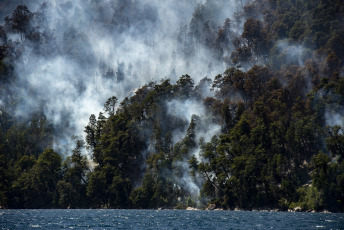 Chubut, Argentina.- En las fotos tomadas el 7 de febrero del 2024, muestra el incendio forestal en el Brazo Tristeza, en el Parque Nacional Nahuel Huapi. Más de 50 brigadistas y dos helicópteros continúan trabajando en la zona sur del Parque Nacional Nahuel Huap para contener el fuego que se desató ayer, pero el área es afectada por "mucho viento", lo que constituye "un factor desfavorable" y propicia un comportamiento más extremo del fuego.